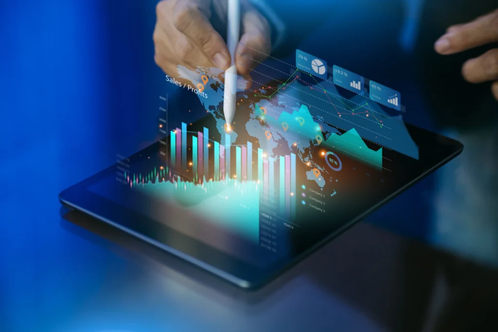Person's hand holding a pen over a tablet, with charts and analytics symbolizing SEO strategy and content optimization.